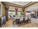Elegant dining room with large windows, tray ceiling, and comfortable seating for Gathering gatherings or formal entertaining at 21384 E Excelsior Ave, Queen Creek, AZ 85142