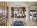 Spacious foyer featuring tile flooring, an elegant arched doorway, and a view into the bright dining room at 21384 E Excelsior Ave, Queen Creek, AZ 85142