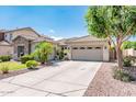 Charming home featuring a lush front yard, stone accents, and a spacious driveway leading to a three-car garage at 2171 E Iris Dr, Chandler, AZ 85286