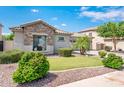 Beautifully landscaped front yard features lush green lawn, vibrant bushes, and elegant stone accents on the facade at 2171 E Iris Dr, Chandler, AZ 85286