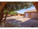 Spacious backyard featuring mature trees, a storage shed, and brick patio, perfect for outdoor entertaining at 240 N Monte Vista St, Chandler, AZ 85225