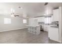 Open-concept living space featuring gray floors, a ceiling fan, and a modern kitchen, perfect for gatherings at 240 N Monte Vista St, Chandler, AZ 85225