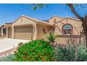 Charming home with desert landscaping, a two-car garage, tile roofing, and solar panels at 27244 W Potter Dr, Buckeye, AZ 85396