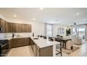 Open-concept kitchen features stainless appliances, a large island with seating, and seamless flow to the living area at 32693 N Jasper St, San Tan Valley, AZ 85143