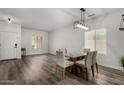 Bright dining room featuring a modern chandelier, glass table, and wood-look flooring at 41678 N Salix Dr, San Tan Valley, AZ 85140