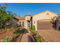 Charming home showcasing meticulous landscaping and a welcoming brick driveway at 4571 N Arbor Way, Buckeye, AZ 85396