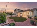 Inviting backyard with lush landscaping, string lights, and a spacious covered patio for outdoor entertaining at 47 W Calle Monte Vis, Tempe, AZ 85284