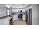Bright kitchen featuring white cabinets, stainless steel appliances, granite countertops, and a stylish tiled backsplash at 4948 W Wikieup Ln, Glendale, AZ 85308