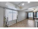 Inviting living room with tile flooring, large windows with curtains, and ample space for furniture and decor at 4948 W Wikieup Ln, Glendale, AZ 85308
