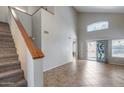 Spacious living room with high ceilings, tile flooring, staircase, and sliding glass doors leading to the backyard at 4948 W Wikieup Ln, Glendale, AZ 85308