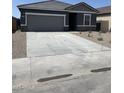 This single-story home features a two-car garage, neutral color scheme, and low-maintenance landscaping at 6041 E Artemis Dr, Florence, AZ 85132