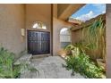 Inviting entryway featuring double doors, neutral tones, tile flooring, and lush plants at 7418 E Black Rock Rd, Scottsdale, AZ 85255