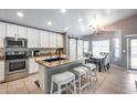 Bright kitchen with granite counters, stainless steel appliances, and adjacent dining area with stylish lighting at 7435 W Trails Dr, Glendale, AZ 85308