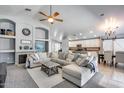 Open-concept living room showcases a cozy fireplace, plush seating, and seamless flow to the kitchen at 7435 W Trails Dr, Glendale, AZ 85308