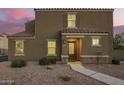 Inviting two-story home featuring a neutral stucco facade and tile roof, complemented by a gravel yard and charming entryway at 8253 W Illini St, Phoenix, AZ 85043