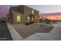 Inviting two-story home featuring a neutral stucco facade and tile roof, complemented by a gravel yard and charming entryway at 8253 W Illini St, Phoenix, AZ 85043