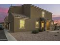 Inviting two-story home featuring a neutral stucco facade and tile roof, complemented by a gravel yard and charming entryway at 8253 W Illini St, Phoenix, AZ 85043