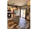 Modern kitchen featuring stainless steel appliances, granite countertops, a center island, and wood-look tile flooring at 17225 W Carmen Dr, Surprise, AZ 85388
