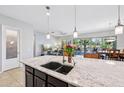 Gourmet kitchen island with granite counters, undermount sink, and views of the backyard at 19002 N Arbor Dr, Maricopa, AZ 85138