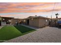 Outdoor backyard area featuring an outdoor kitchen, artificial grass, and paver patio at 19615 N 18Th Dr, Phoenix, AZ 85027