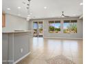 Spacious living room with tile flooring, ceiling fan, and sliding doors that lead to an outdoor patio at 21532 N 262Nd Ln, Buckeye, AZ 85396