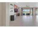 Open-concept living room with large windows, tile flooring, and a unique accent wall at 2518 E Novak Way, Phoenix, AZ 85042