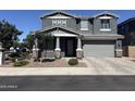 Charming gray two-story home featuring stone accents, a well-manicured yard, and an attached two-car garage at 4490 S Montana Dr, Chandler, AZ 85248
