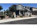 Charming gray two-story home featuring stone accents, a well-manicured yard, and an attached two-car garage at 4490 S Montana Dr, Chandler, AZ 85248