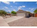 Single-story home featuring a two-car garage and low-maintenance desert landscaping, near a playground at 4518 W Carson Rd, Laveen, AZ 85339