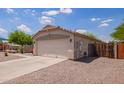 Single-story home featuring a two-car garage and low-maintenance desert landscaping, near a playground at 4518 W Carson Rd, Laveen, AZ 85339