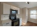 Kitchen boasts stainless steel microwave and black oven, with white countertops and sleek hardware and an adjacent dining area at 6434 W Riva Rd, Phoenix, AZ 85043