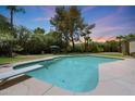 Inviting pool with a diving board and plenty of room for swimming in a large backyard with ample greenery at 6911 E Thunderbird Rd, Scottsdale, AZ 85254