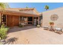 Front entrance with carved wooden door and chairs on the patio at 6931 E Pershing Ave, Scottsdale, AZ 85254