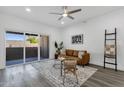 Open living room with a sliding glass door to the balcony, wood floors, and sleek modern decor at 8020 E Thomas Rd # 313, Scottsdale, AZ 85251
