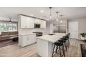 Bright, open kitchen features white cabinets, a large island with seating, and modern stainless steel appliances at 8713 E Citrus Way, Scottsdale, AZ 85250