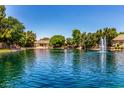 Scenic view of a lake with a fountain, surrounded by lush greenery and waterfront homes on a sunny day at 941 N Benson Ln, Chandler, AZ 85224