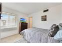 Cozy bedroom featuring a twin bed, neutral color palette, and ample natural light from the window at 1122 E Michelle Dr, Phoenix, AZ 85022