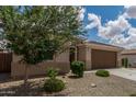 Single-story home with a well-kept yard, two-car garage, neutral colors and desert landscaping at 12289 E Ballentine Rd, Gold Canyon, AZ 85118