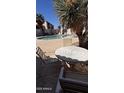 Relaxing poolside seating area with table and chairs near lush landscaping at 1440 N Idaho Rd # 1022, Apache Junction, AZ 85119
