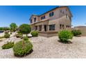 Side view of the two-story home with desert landscaping, showing windows, and a tiled roof at 16450 W Lilac St, Goodyear, AZ 85338