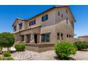 Corner view of the two-story home with desert landscaping, showing windows, and a tiled roof at 16450 W Lilac St, Goodyear, AZ 85338
