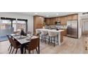 Modern kitchen with stainless steel appliances, an island, and sleek countertops adjacent to dining area at 1713 W Royal Palm Rd, Phoenix, AZ 85021