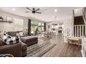 Open-concept living space with wood floors, a modern fan, and seamless flow to the kitchen and dining area at 1882 S Jesse Pl, Chandler, AZ 85286