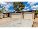 The front exterior features a charming brick facade, a two-car garage, and desert landscaping at 19013 N 18Th Ave, Phoenix, AZ 85027