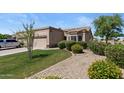 Beautiful exterior of home with desert landscaping, mature tree, and attached garage at 19530 N 84Th Ave, Peoria, AZ 85382