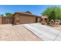 Charming single-story home featuring a two-car garage and desert landscaping at 2223 S Hughes Dr, Buckeye, AZ 85326