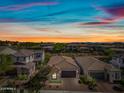 An aerial view showcases a home with desert landscaping in a community under a colorful sky at 2315 W Duane Ln, Phoenix, AZ 85085