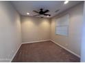 Clean, empty bedroom with a ceiling fan, one window with blinds, and neutral carpet at 26747 W Pontiac Dr, Buckeye, AZ 85396