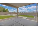 Spacious covered patio overlooking a large backyard with manicured grass and stone accents at 3586 S Moccasin Trl, Gilbert, AZ 85297
