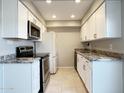 Updated kitchen with white cabinets, granite countertops, and stainless steel appliances for a modern look at 3840 N 43Rd Ave # 34, Phoenix, AZ 85031